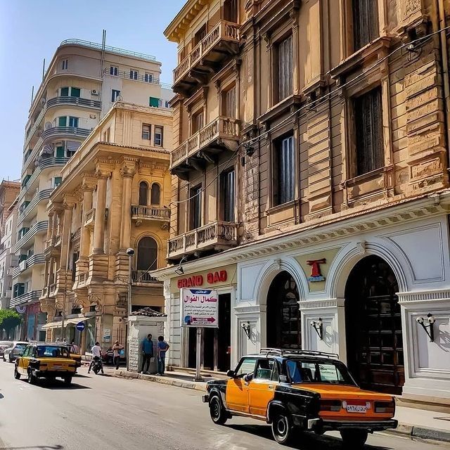 cars are driving down the street in front of buildings