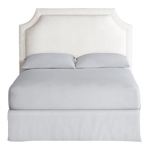 a white bed with two pillows on top of it and a pillow under the headboard