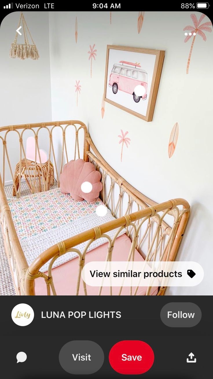 a baby crib with pink and white decor on the walls