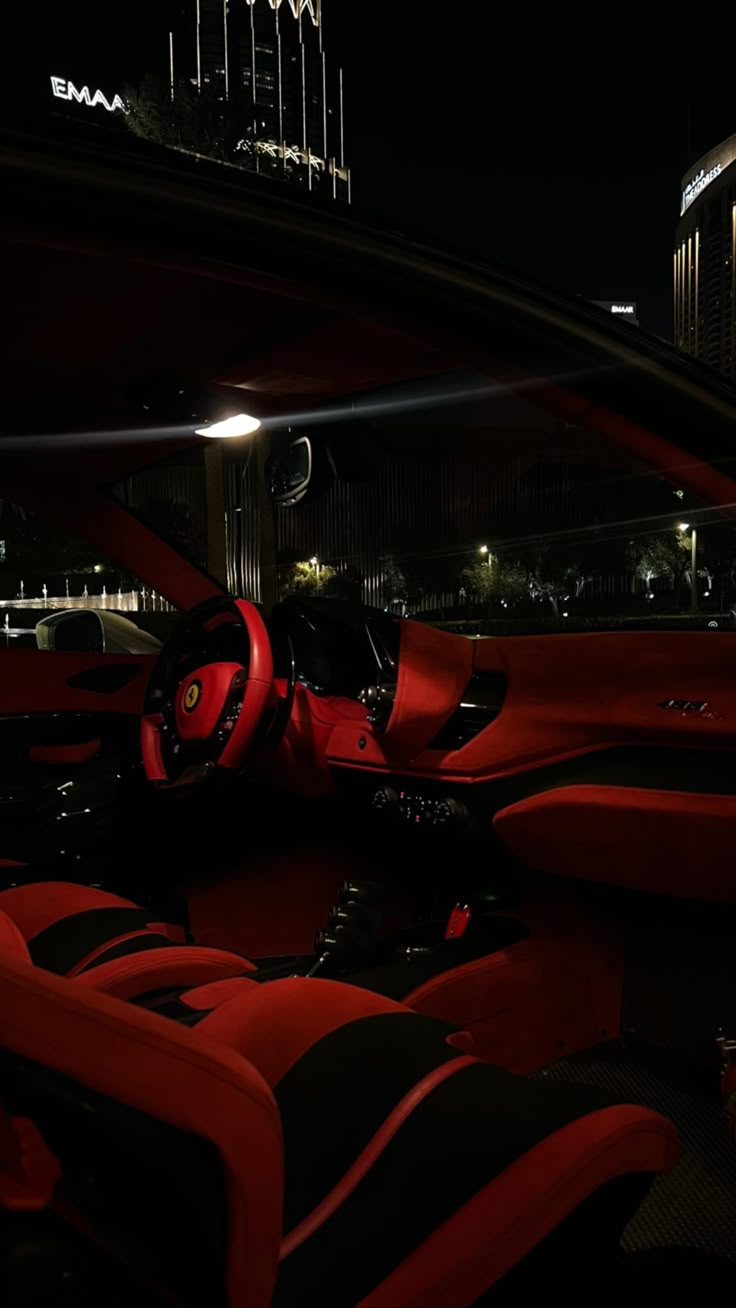 the interior of a modern car with red leather seats and black trims at night