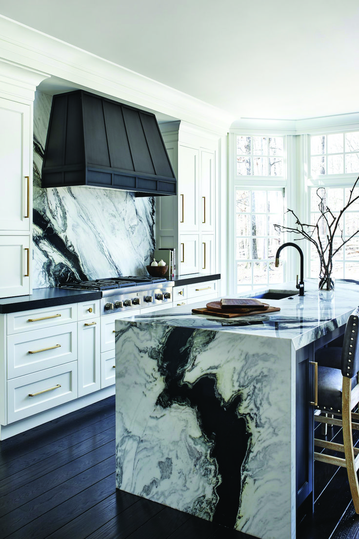 a kitchen with marble counter tops and white cabinets in the center, along with an island