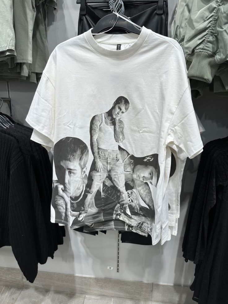 a t - shirt with the image of two men on it hanging in a clothing store