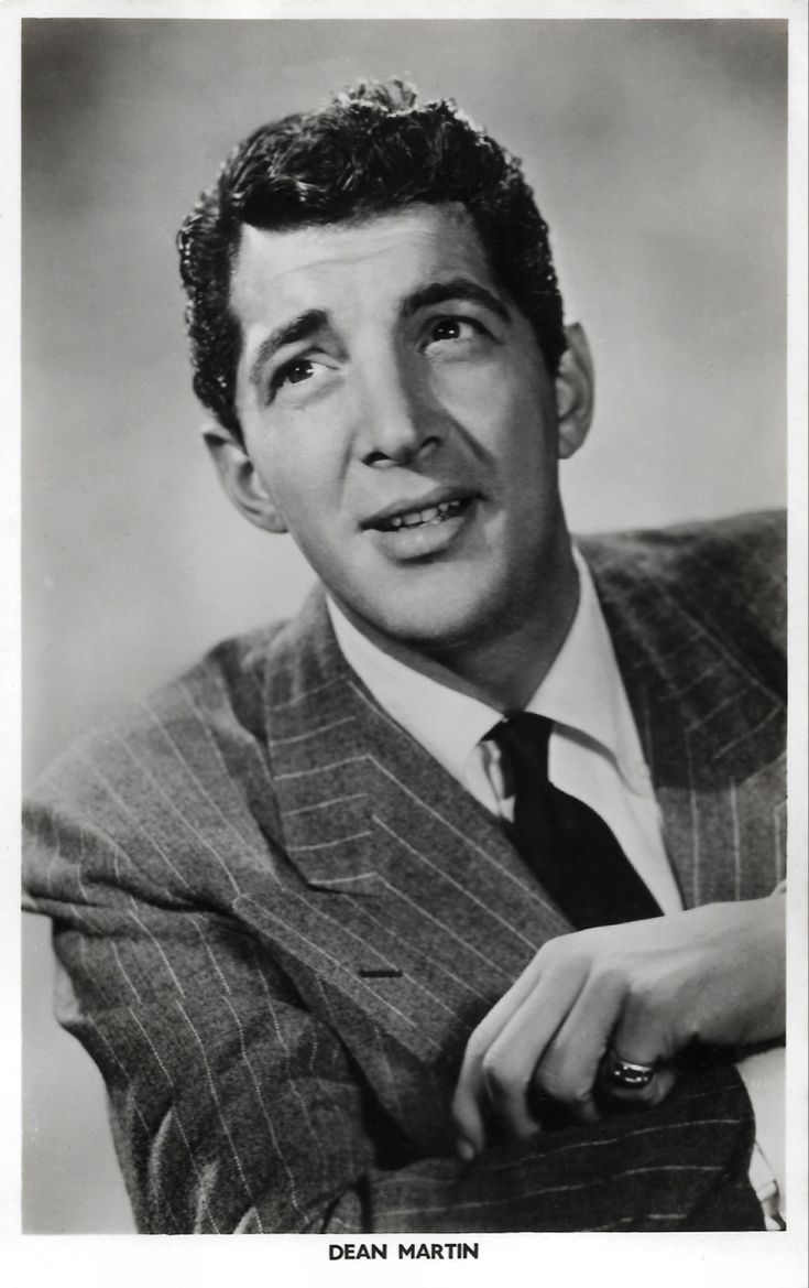 an old black and white photo of a man in a suit with his hand on his lap