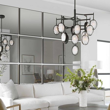 a living room filled with white furniture and lots of mirrors