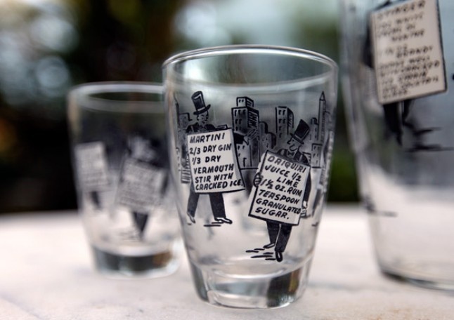 three shot glasses sitting on top of a table next to each other with signs in them