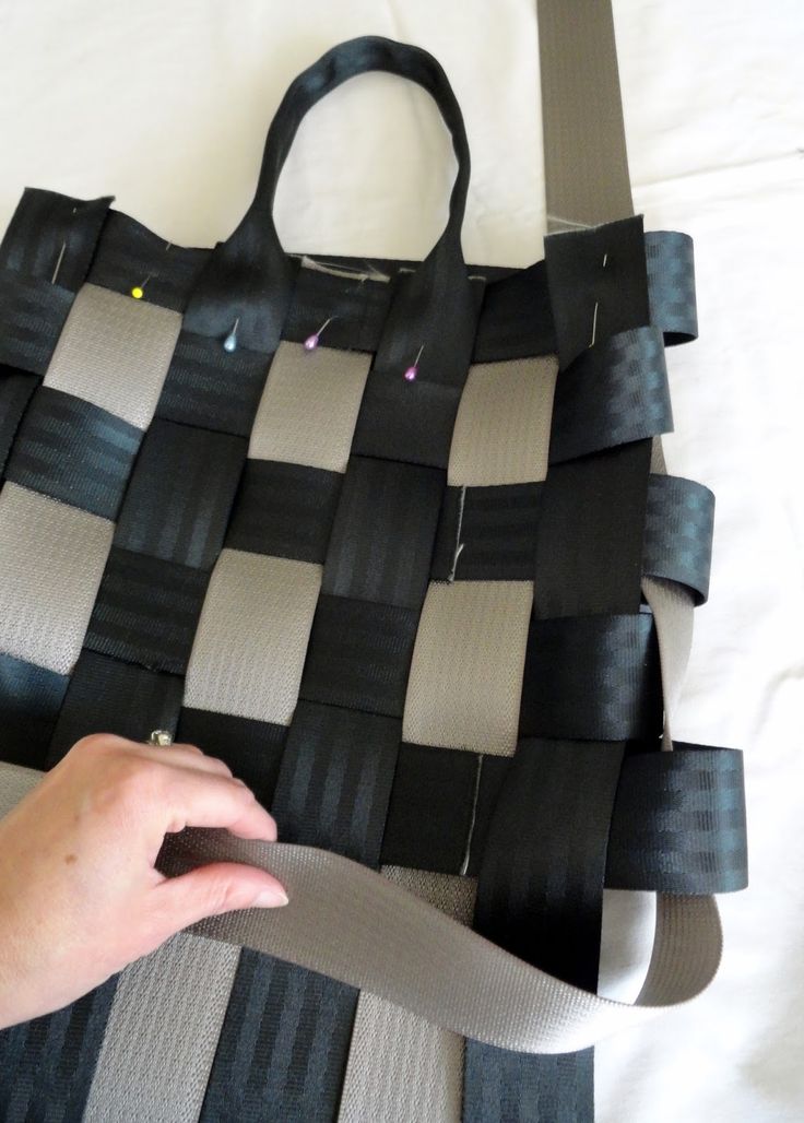 a person is holding onto a black and white bag made out of strips of duct tape