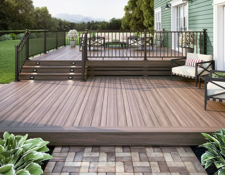 a wooden deck with chairs on it next to a green house and some plants in the foreground