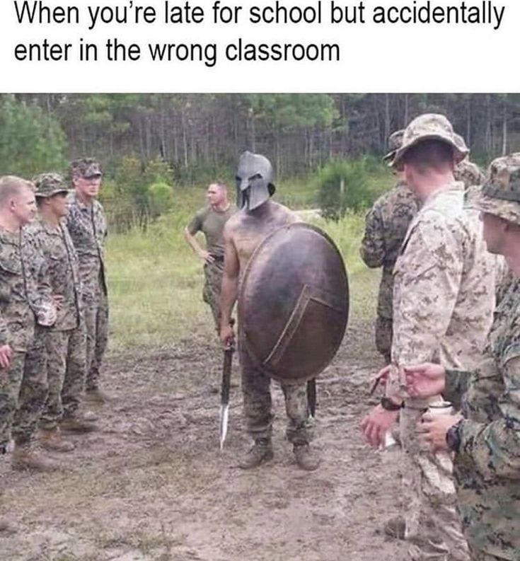 some soldiers are talking to each other and one is holding a large metal object in his hand