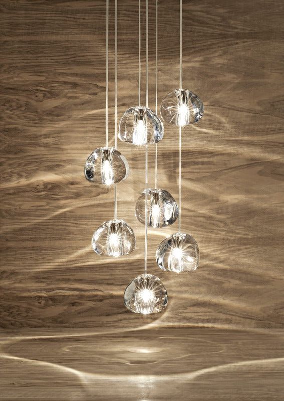 a chandelier hanging from a wooden ceiling with glass balls on the bottom and sides