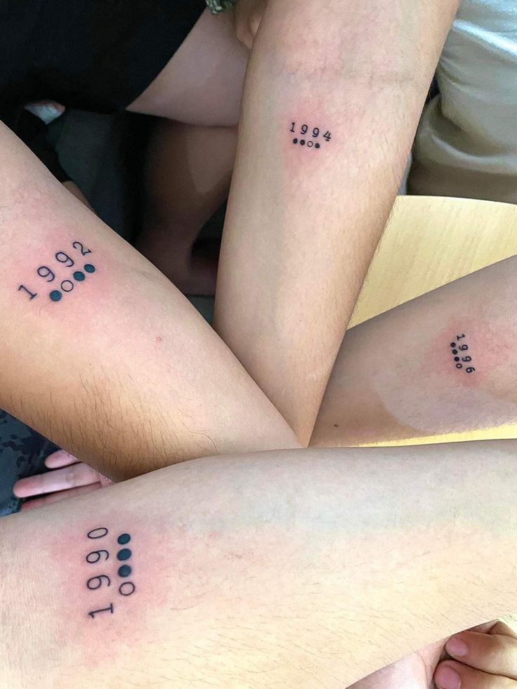 three people with matching tattoos on their legs