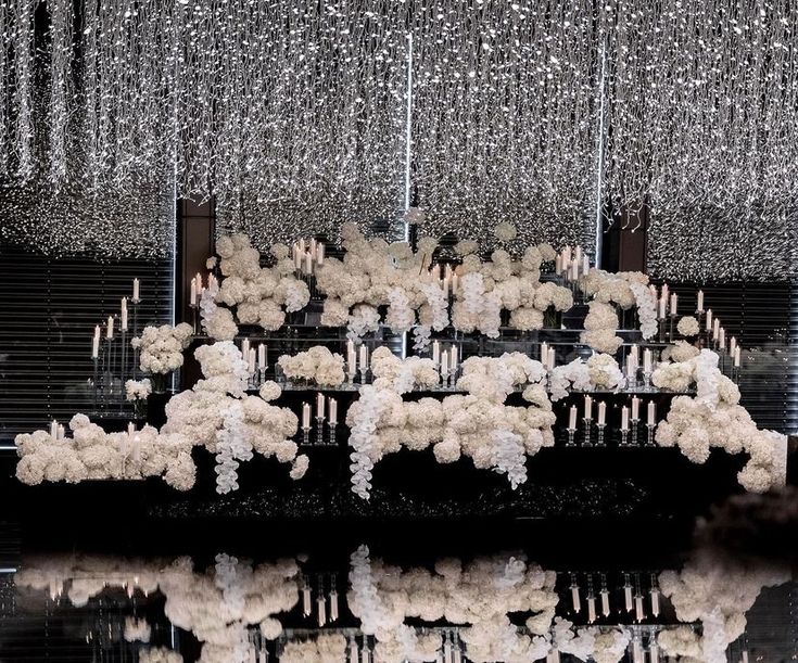 an artistic display with white flowers and chandeliers