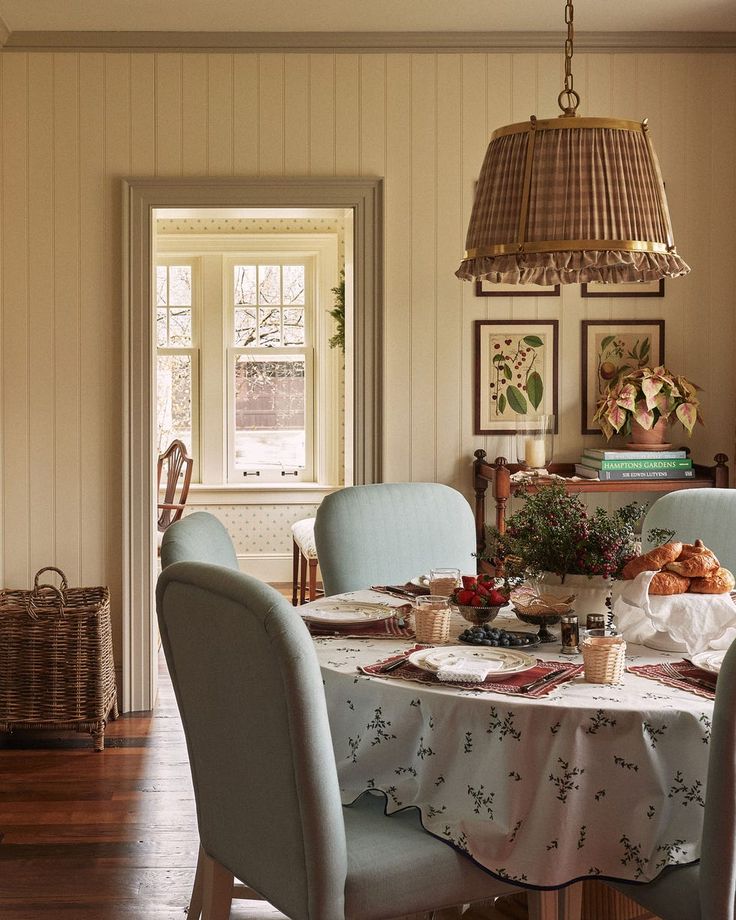 a dining room table with chairs and a basket hanging from the ceiling