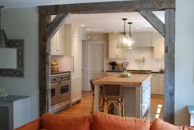 an open kitchen and living room area with couches in front of the stove top oven