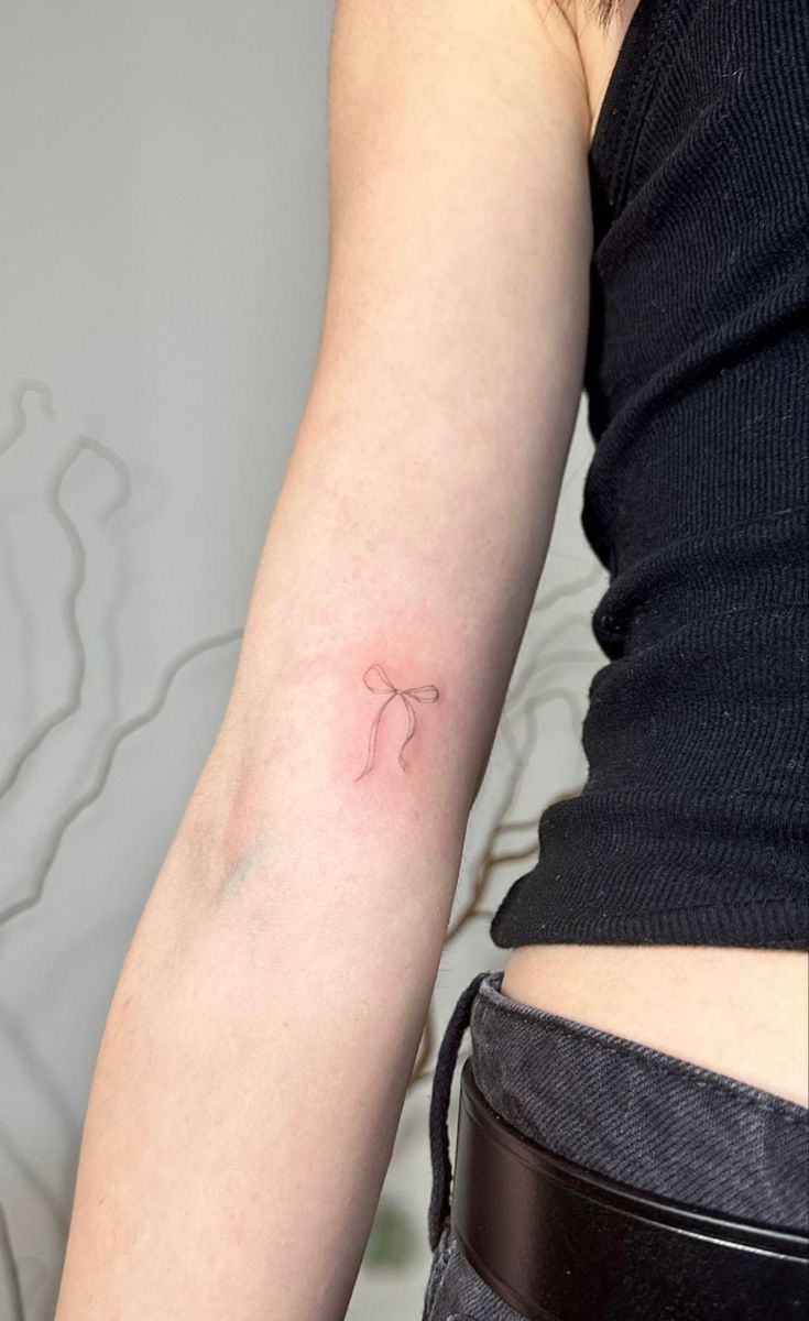 a woman's arm with a small tattoo on the left side of her arm