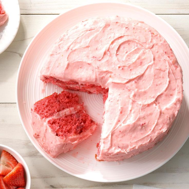 a cake that has been cut into pieces and is on a plate with strawberries