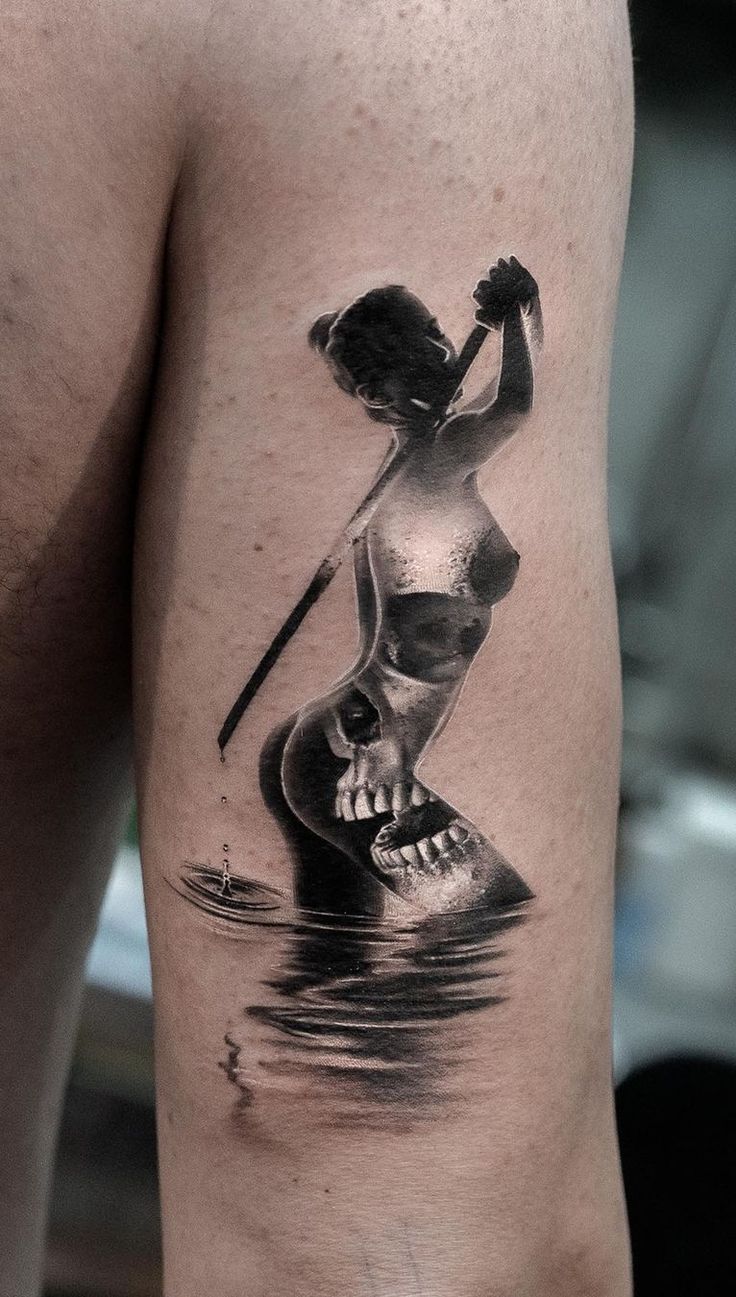 a man with a skull tattoo on his arm holding a baseball bat in the water