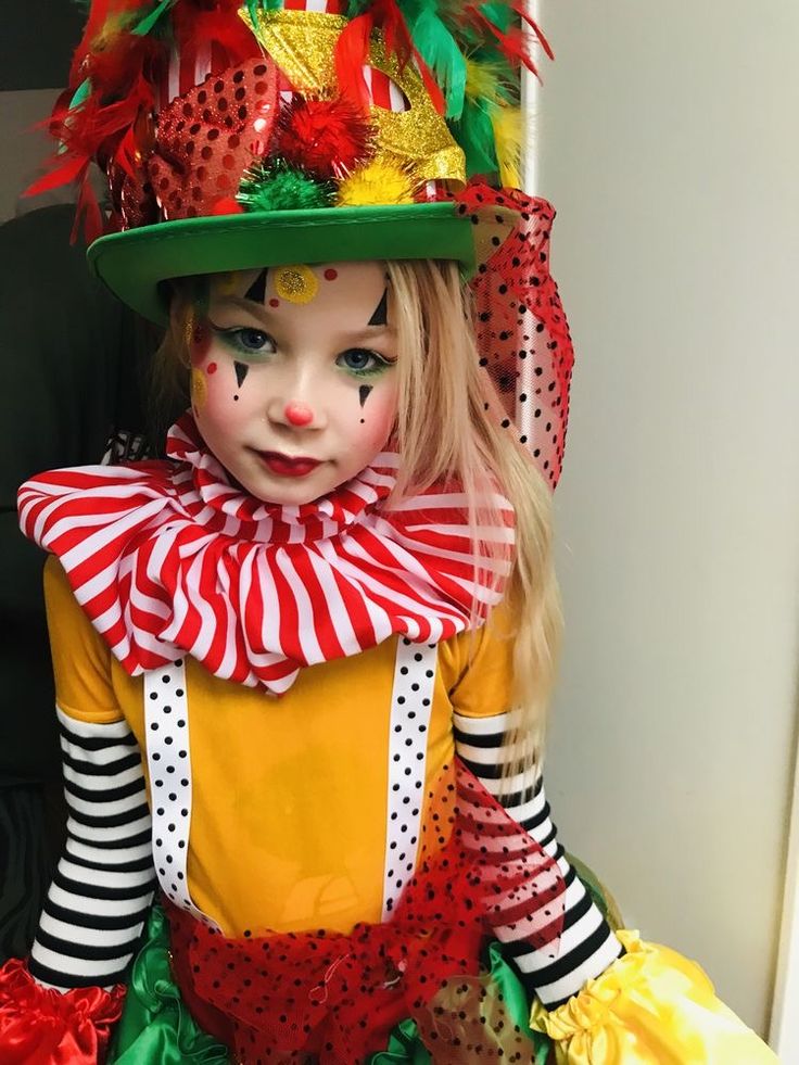 a close up of a child wearing a clown costume