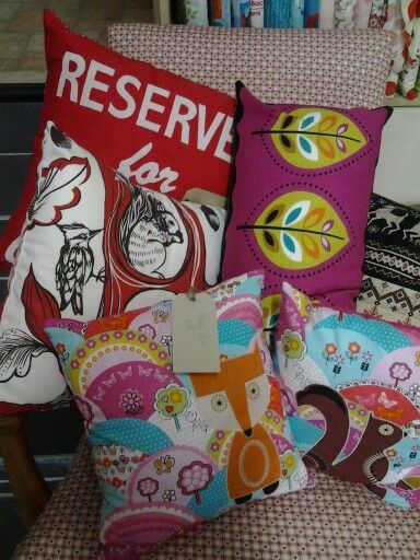 several decorative pillows on a chair in a room