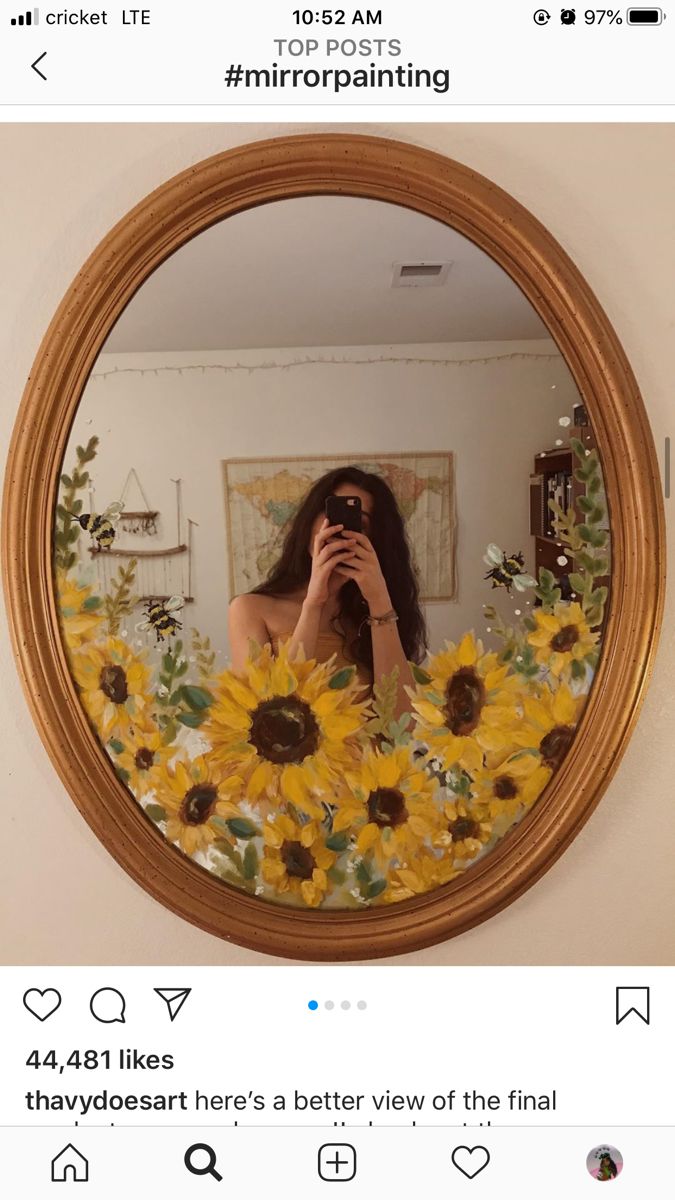 a woman taking a selfie in front of a mirror with sunflowers on it