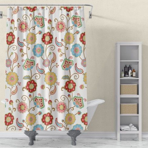 a shower curtain with colorful flowers on it in a white bathroom next to a bathtub