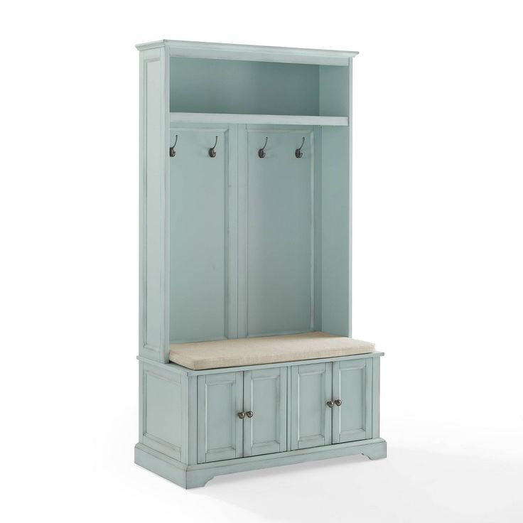 a blue cabinet with two doors and some hooks on the top shelf, sitting against a white background