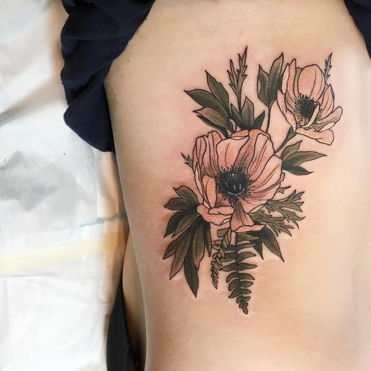 a woman's lower back tattoo with flowers on it