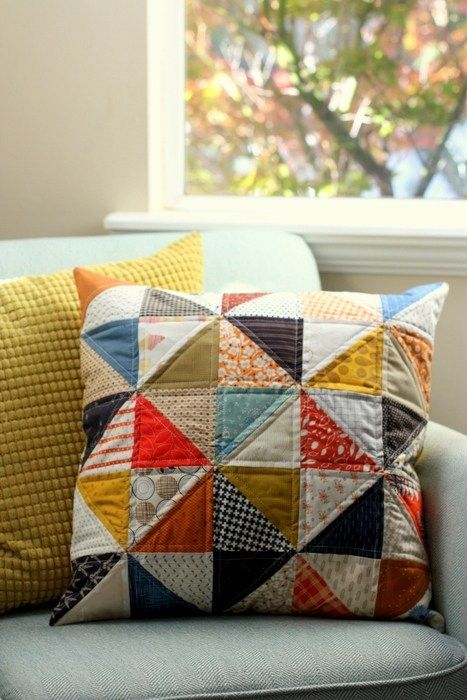 a blue chair with two pillows on it and a window in the backround