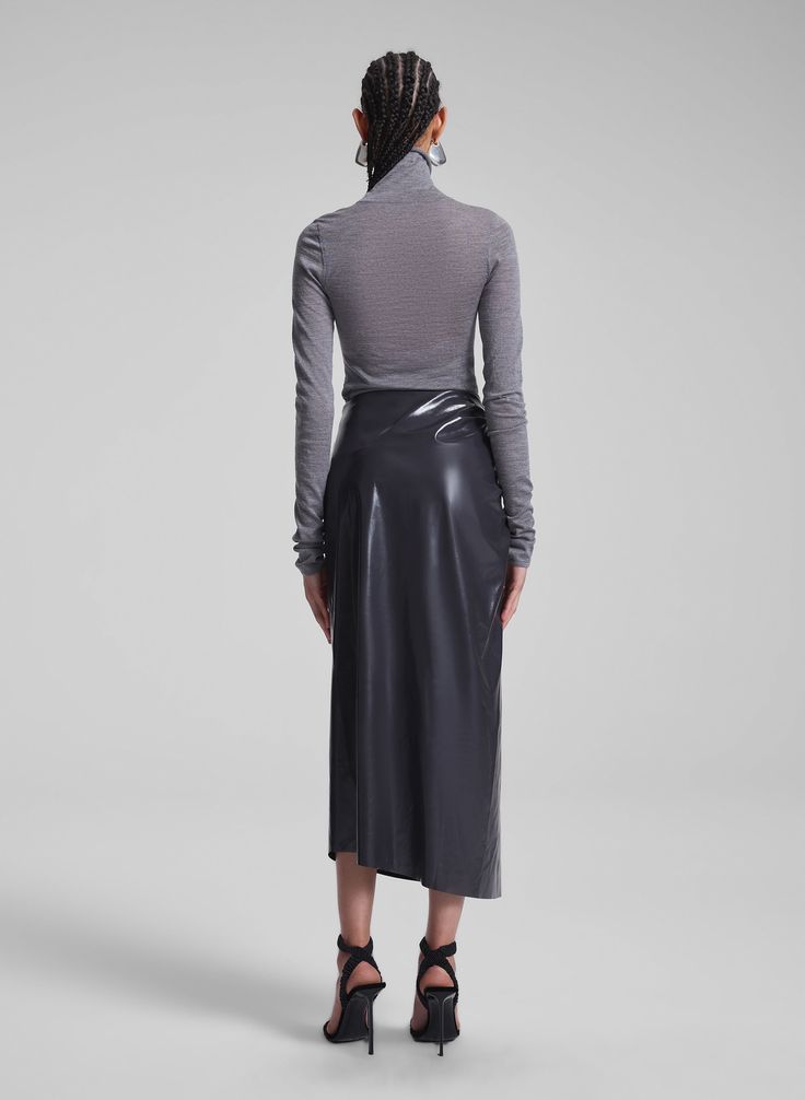 The Tessa Skirt is crafted from patent vegan leather in a smoky grey hue, offering a high-shine finish that mimics genuine patent leather. This midi silhouette features asymmetrical ruched detailing at the hip for a modern, polished look. Shop Bottoms. Styling Tip: Offset with a sumptuous knit or a crisp button-down for a balanced, elevated look. Denim Sweater Jacket, Leather Midi Skirt, Denim Sweater, Empowering Women, Sweater Sale, Jacket Sale, Polished Look, Sweater Jacket, Denim Dress