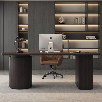 an office desk with a laptop on it in front of a bookshelf filled with shelves