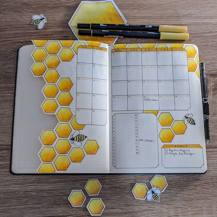 an open notebook with bees and honeycombs on it