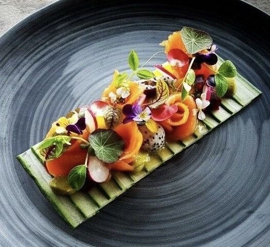 a plate that has some kind of food on top of it with leaves and flowers