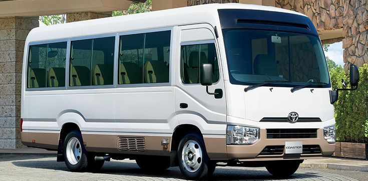 a white bus parked in front of a building