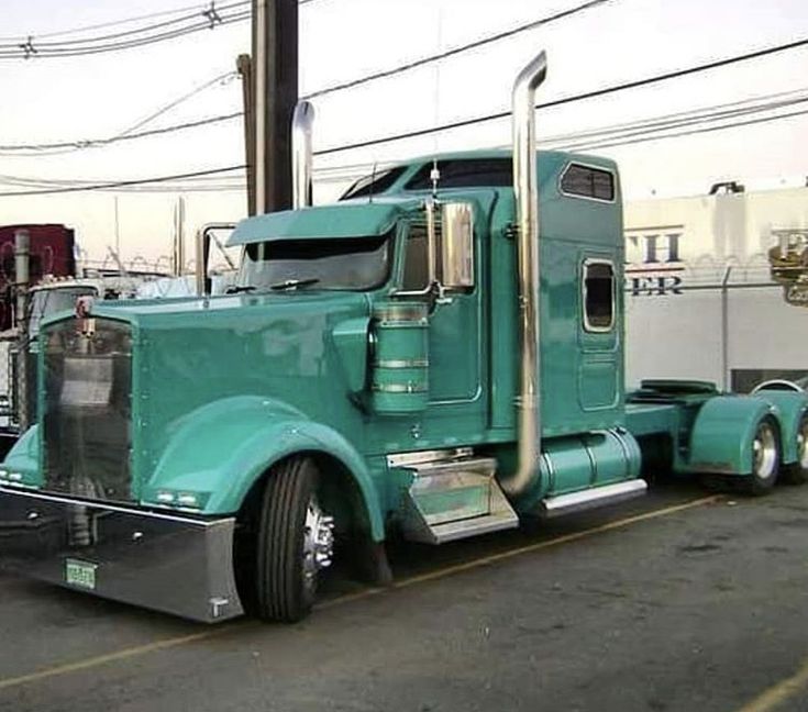 a green semi truck parked in a parking lot