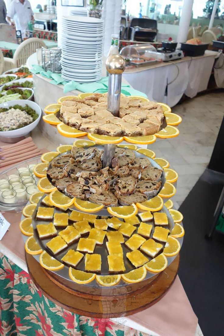 an assortment of desserts are displayed on a buffet table