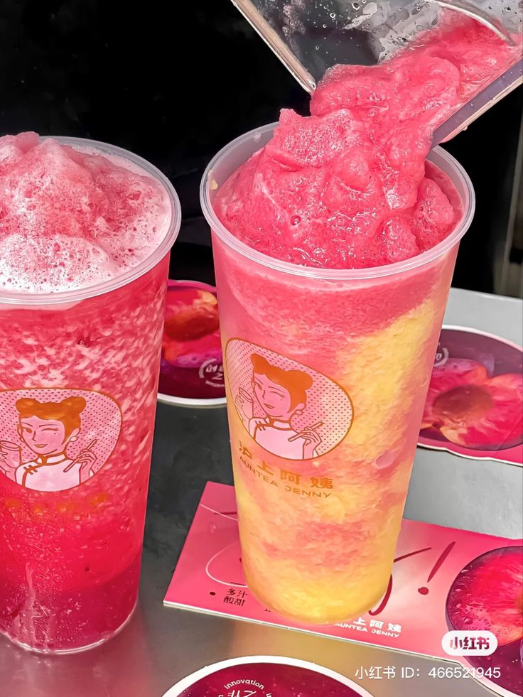 two plastic cups filled with pink colored liquid