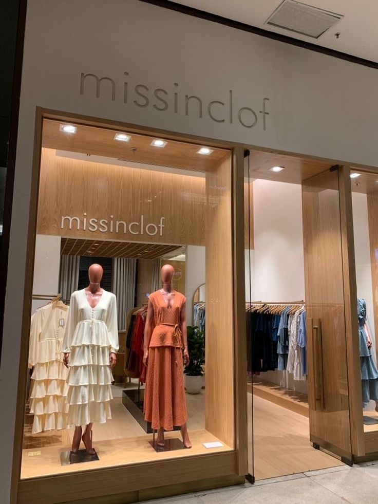 two mannequins in front of a store window with the words missniclof on it