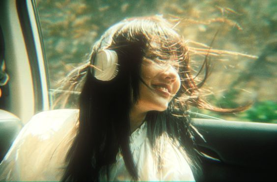 a woman with headphones sitting in a car