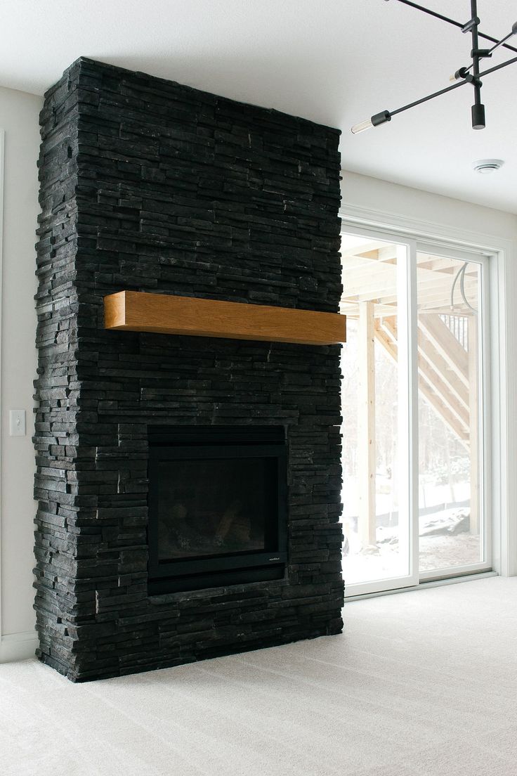 an empty living room with a fireplace and sliding glass doors