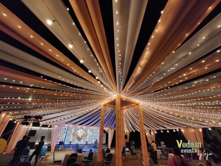 the ceiling is decorated with white lights and draping for a wedding or reception