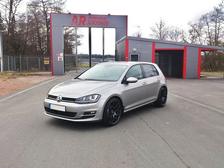 a silver car parked in front of a garage