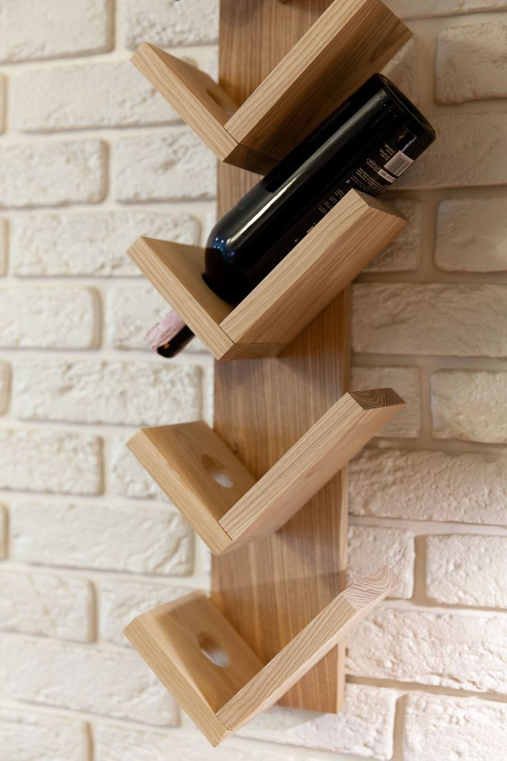 a wine bottle is sitting on top of a wooden shelf next to a brick wall