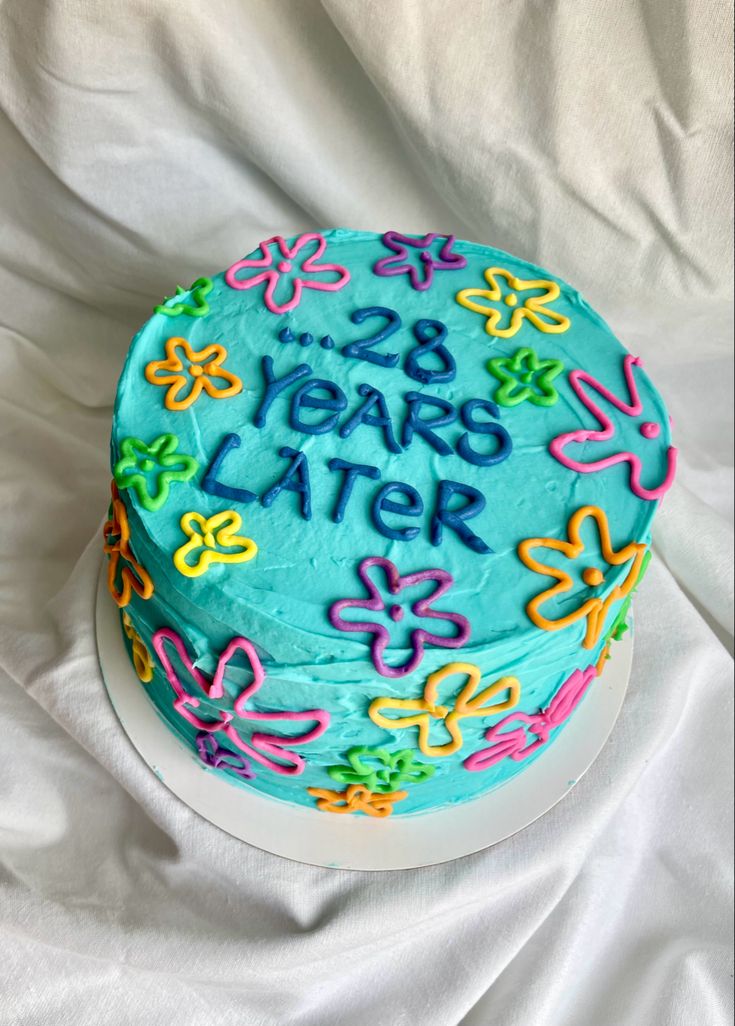 a birthday cake with the words 28 years later written on it and decorated with flowers