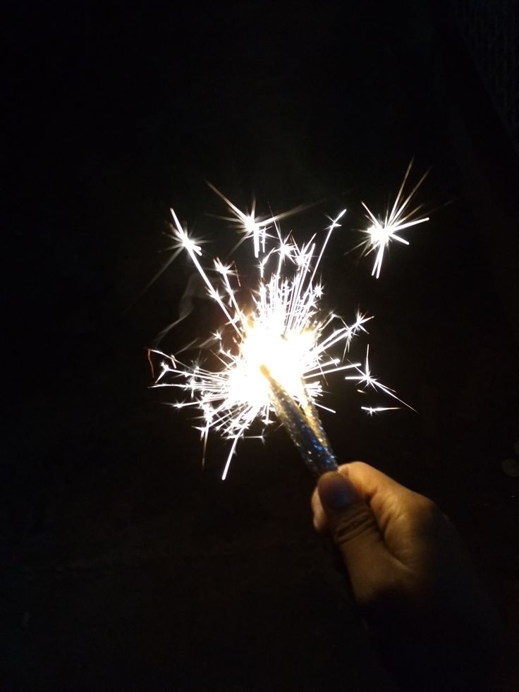 someone holding a sparkler in their hand at night