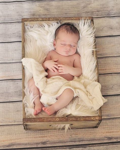 a baby is sleeping in a wooden box