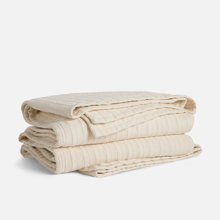 three folded blankets stacked on top of each other