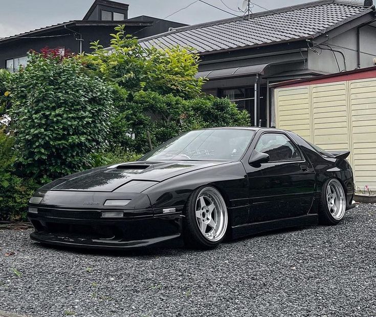 a black car parked in front of a house