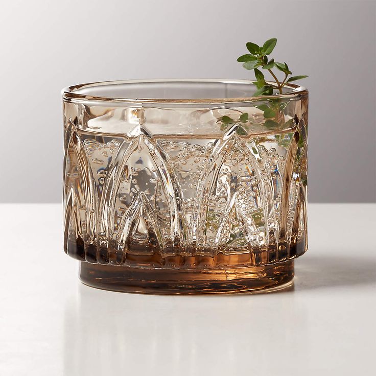 a glass vase with some plants in it