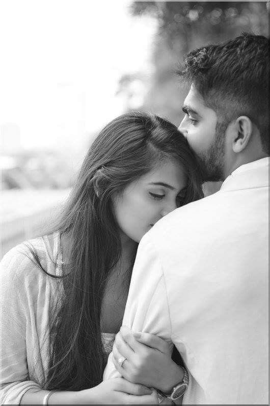 a man and woman embracing each other in black and white