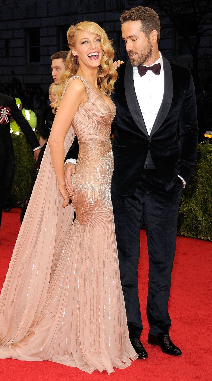 a man and woman standing next to each other on a red carpet