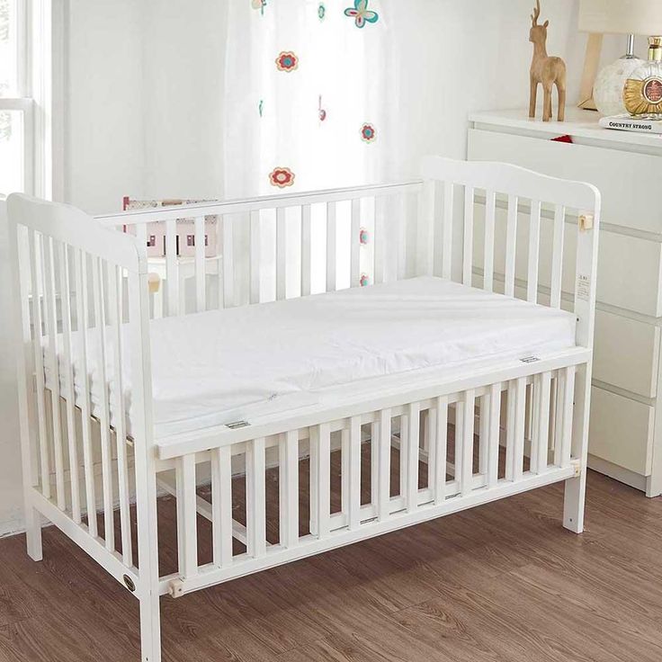 a white crib in the corner of a room